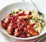 Pomegranate chicken with almond couscous in a white bowl